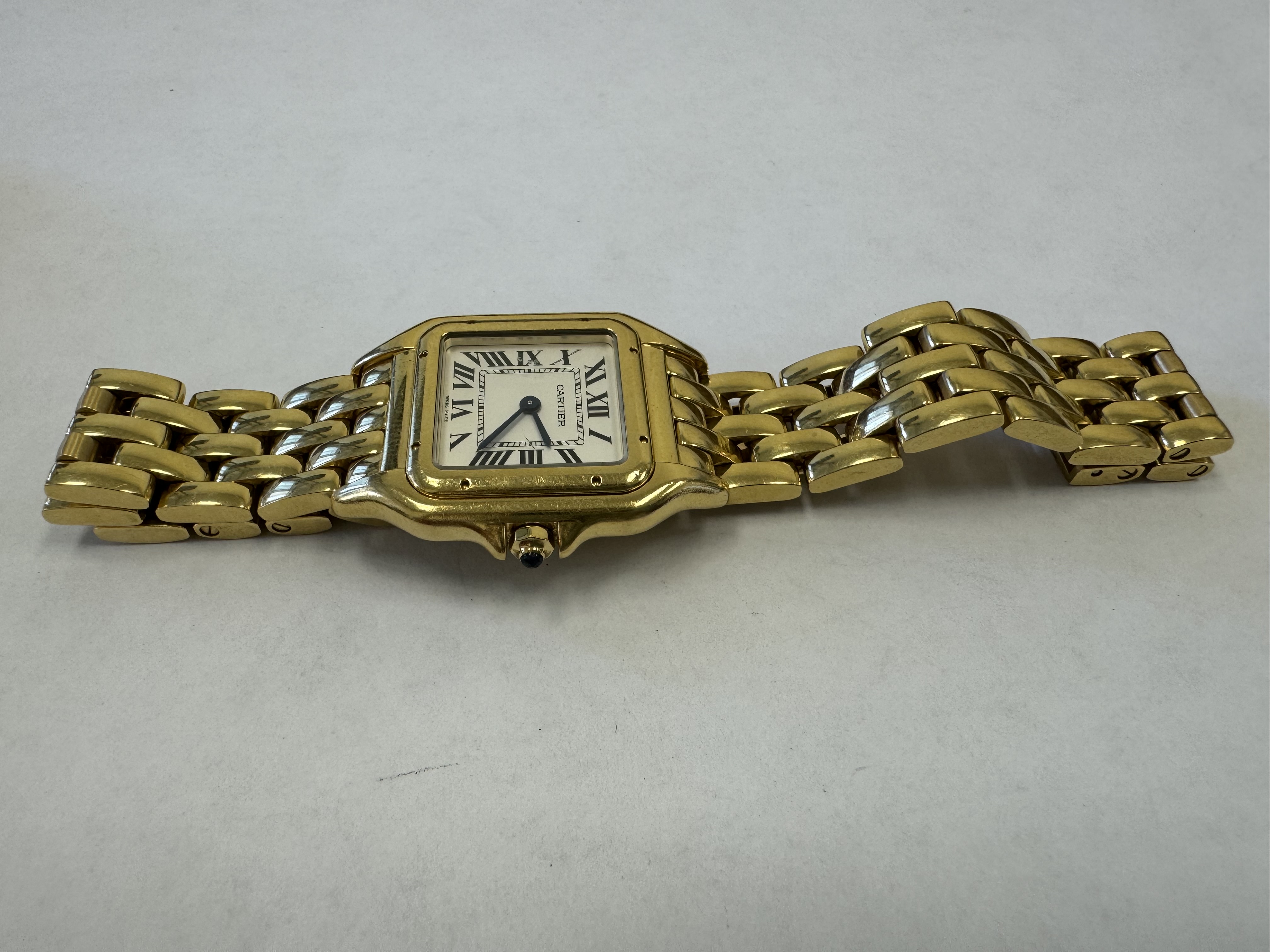 Наручные часы «Cartier Pandere de Cartier ref. WGPN0009», корпус прямоугольный, из металла золотистого цвета, браслет из металла золотистого цвета с замком. На оборотной стороне часов имеется штампованная надпись «CARTIER», «SWISS MADE», «WATER RESISTANT», «39068WX 4014», «Аu750», б/у