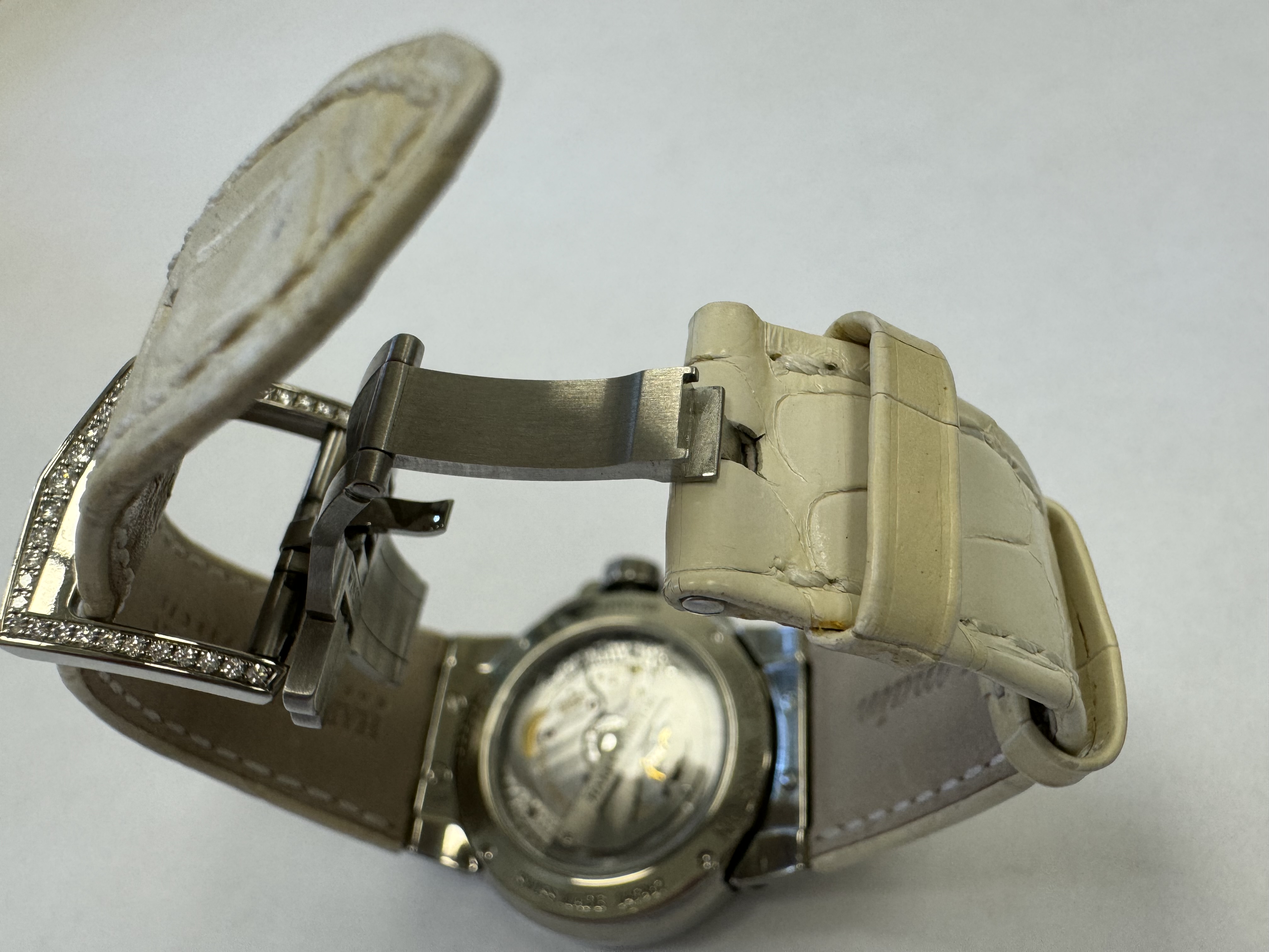 Наручные часы «Наrrу Winston Осеаn Lady Z Moonphase 400/UAMP36ZL.WDR/D3.1» Корпус круглый из металла серебристого цвета со вставками из прозрачных камней по кругу. Ремешок из металла белого цвета с замком из металла серебристого цвета, на оборотной стороне штампованная надпись «HARRY WINSTON», «Zalium № 08/50», «SWISS MADE 045967», «400 UAMP36Z», б/у.