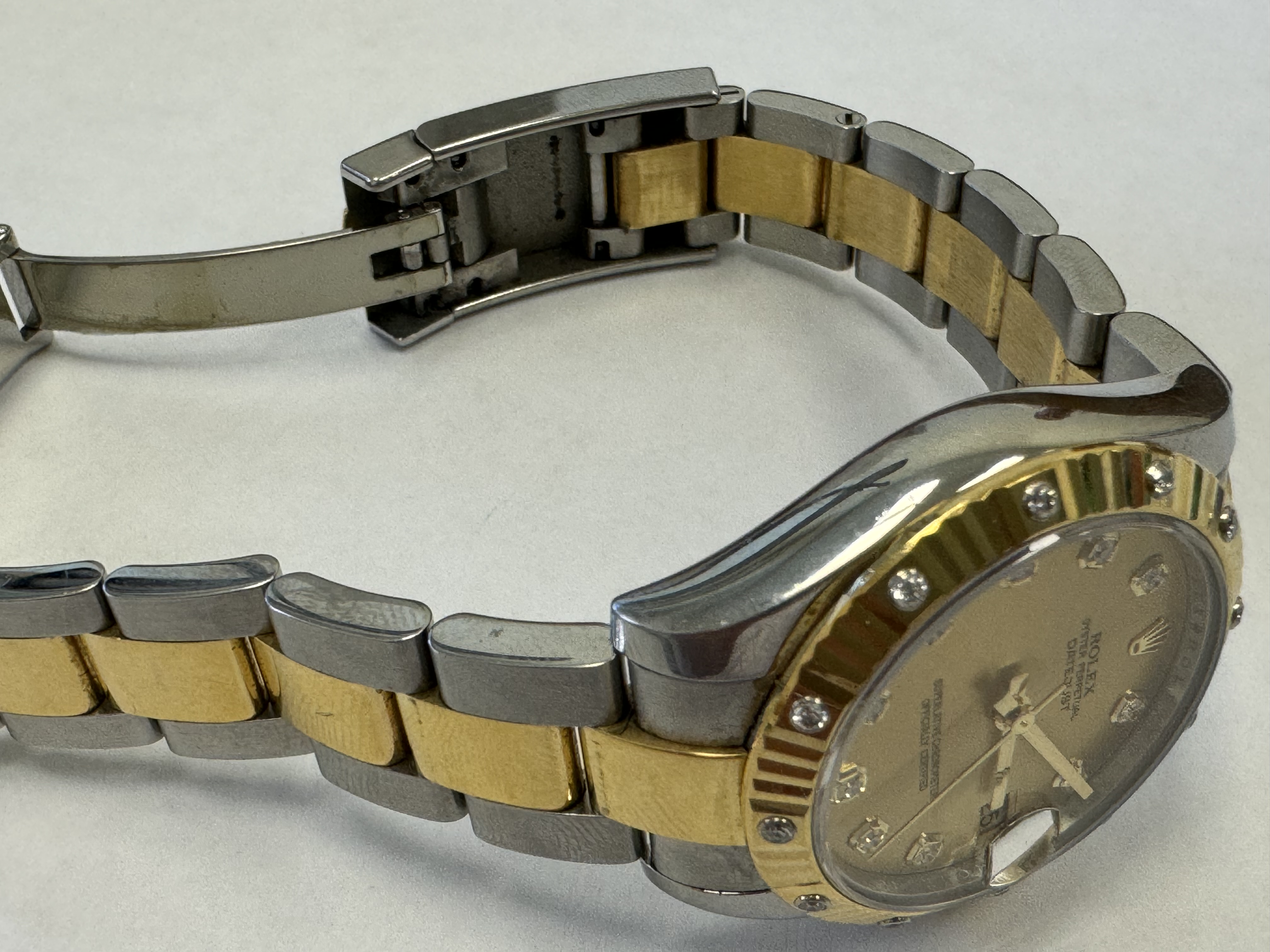 Наручные часы «Rolex Datejust ref. 178313» (на часах указан идентификационный номер «J9215513»), корпус круглый из металла серебристого цвета со вставкой из металла золотистого цвета и прозрачными камнями по кругу и на циферблате часов. Браслет из металла серебристого цвета с золотистой вставкой в центре и с замком. На замке штампованная надпись «ROLEX», «GENEVA», «SWISS MADE», б/у.