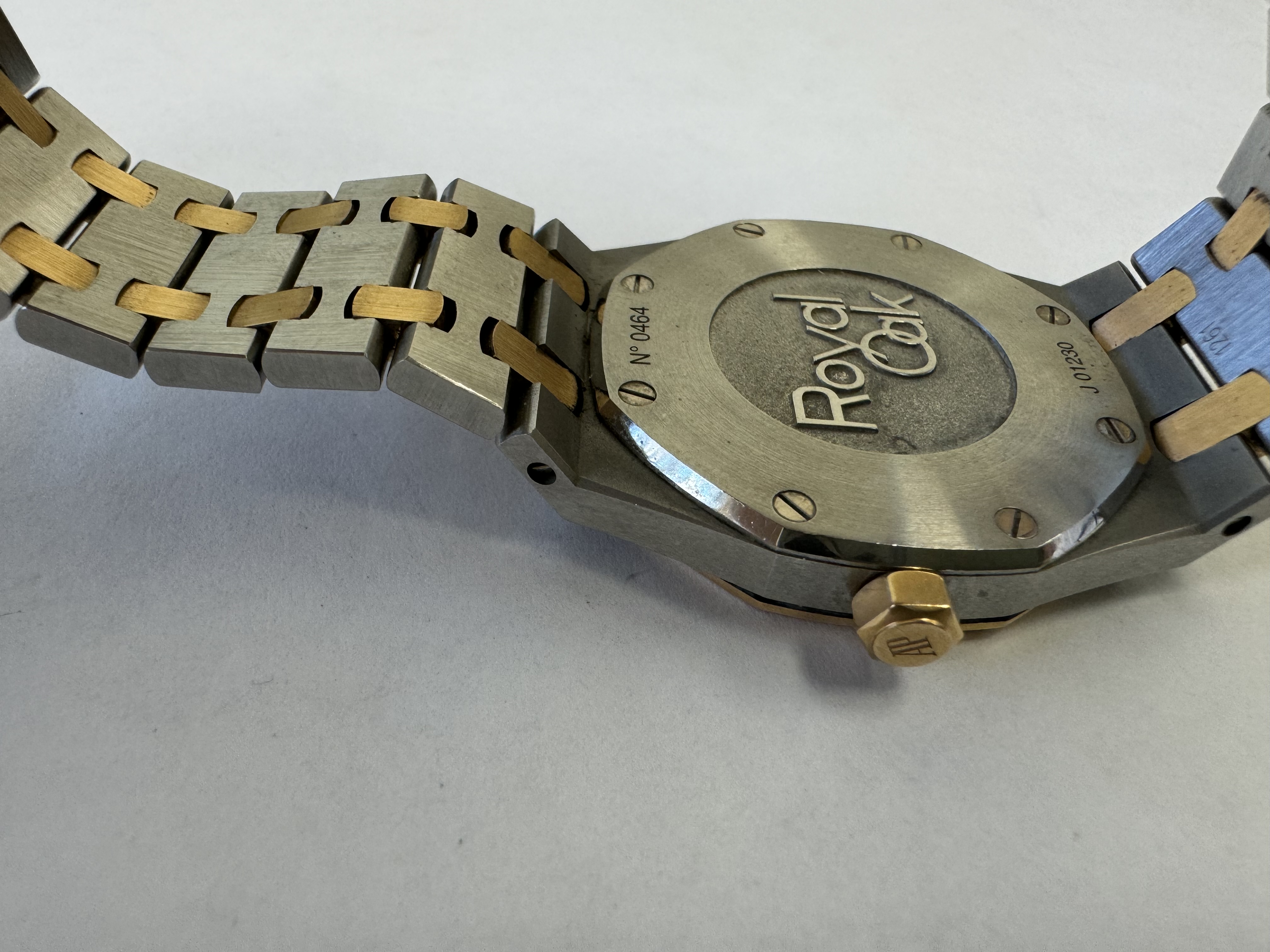 Наручные часы «Audemars Piguet Royal Оаk Quartz Ladies 67651SR.ZZ.1261SR.01», корпус ромбовидный, из металла серебристого цвета со вставкой золотистого цвета; по кругу — вставка из прозрачных камней. Браслет из металла серебристого цвета со вставками золотистого цвета с замком. На оборотной стороне штампованная надпись «ROYAL OAK», «№ 0464», «J 01230», б/у