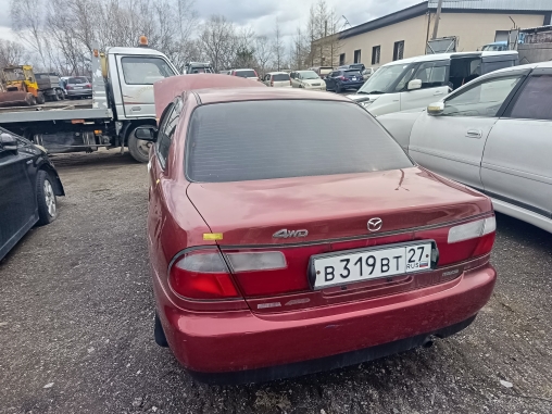 Автомобиль марки MAZDA FAMILIA г/н В319ВТ27,1986 г.в., № кузова BHA6R302328.красного цвета, имеются повреждения переднего бампера, вмятина на капоте.