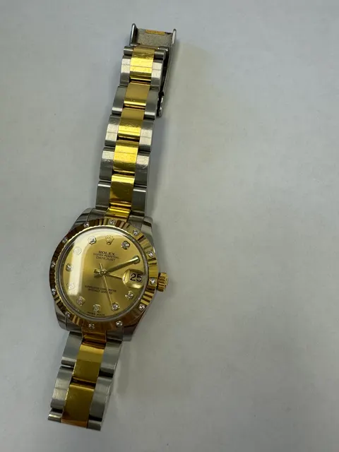 Наручные часы «Rolex Datejust ref. 178313» (на часах указан идентификационный номер «J9215513»), корпус круглый из металла серебристого цвета со вставкой из металла золотистого цвета и прозрачными камнями по кругу и на циферблате часов. Браслет из металла серебристого цвета с золотистой вставкой в центре и с замком. На замке штампованная надпись «ROLEX», «GENEVA», «SWISS MADE», б/у.