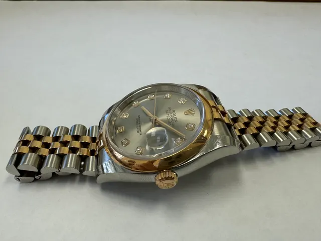 Наручные часы «Rolex Datejust ref. 116203» (на часах указан идентификационный номер «S7776635») ,корпус круглый, из металла серебристого цвета со вставкой из металла золотистого цвета и прозрачными камнями на циферблате, браслет из металла серебристого цвета с золотистой вставкой в центре и с замком. На замке штампованная надпись «ROLEX», «GENEVA», «SWISS MADE», б/у
