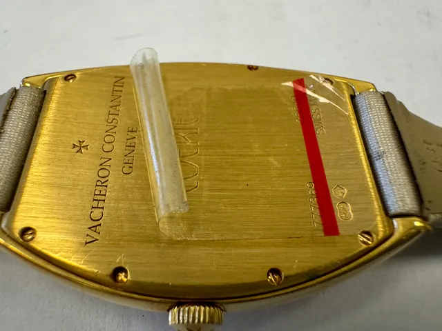 Наручные часы «Vacheron Constantin Egerie ref. 25540», корпус овальный из металла золотистого цвета со вставкой из прозрачных камней по кругу. Ремешок из материала светлого цвета с замком из металла золотистого цвета, на оборотной стороне штампованная надпись «VACHERON CONSTANTIN», «GENEVE», «777369», «25540», б/у.