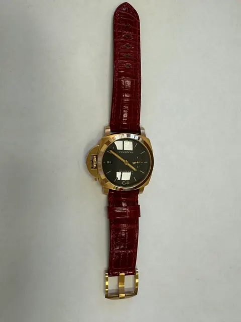 Наручные часы «Panerai Luminor Marina 1950 З Days ref. РАМ00З9З»»,корпус круглый, из металла золотистого цвета, ремешок из материала красного цвета с замком из металла золотистого цвета. На оборотной стороне штампованная надпись «OFFICINE PANERA», «0 130/500», «BB1538538», «OP 6889», «Au750», «50m», б/у