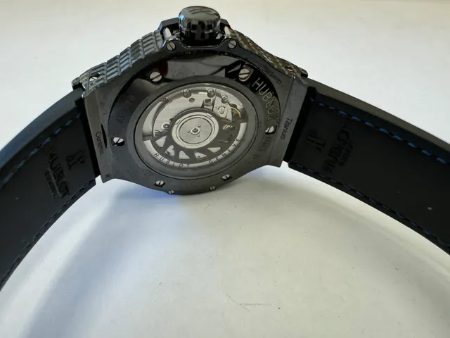 Наручные часы «Hublot Big Bang Tutti Fruitti Dark Blue Caviar ref. 346.CD.1800.LR.1901»в круглом корпусе из металла темного цвета со вставками синего цвета. Часы имеют ремешок из материала синего цвета с замком из металла черного цвета. На оборотной стороне часов имеется надпись «HUBLOT», «BIG BANG», «946159», б/у