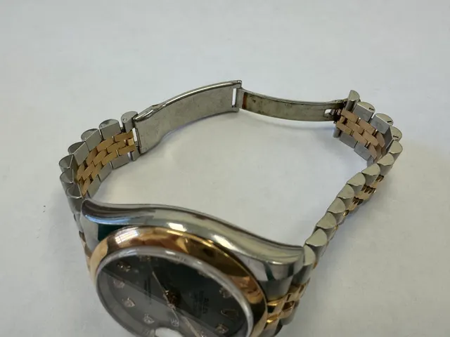 Наручные часы «Rolex Datejust ref. 116203» (на часах указан идентификационный номер «S7776635») ,корпус круглый, из металла серебристого цвета со вставкой из металла золотистого цвета и прозрачными камнями на циферблате, браслет из металла серебристого цвета с золотистой вставкой в центре и с замком. На замке штампованная надпись «ROLEX», «GENEVA», «SWISS MADE», б/у